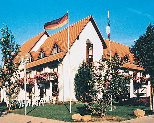 Scenic exterior view of a unit with multiple balconies and flags at Residenz Mandelgarten Deidesheim.