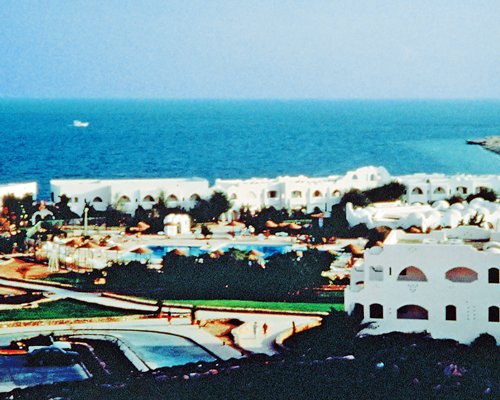 Exterior view of Domina Coral Bay Resort & Casino alongside ocean.