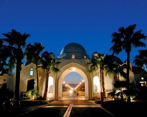 Entrance to Domina Coral Bay Resort & Casino with palm trees.