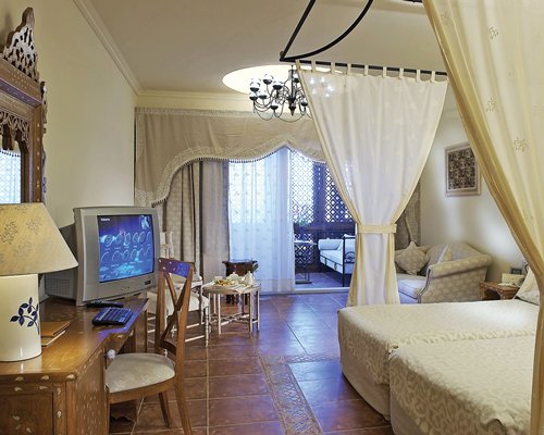 A well furnished bedroom with two twin beds television and outdoor living area.