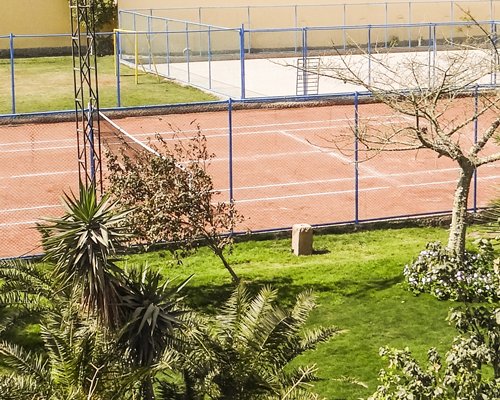 Outdoor recreation area with tennis court and volleyball court.
