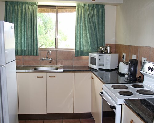 A well equipped kitchen with outside view.