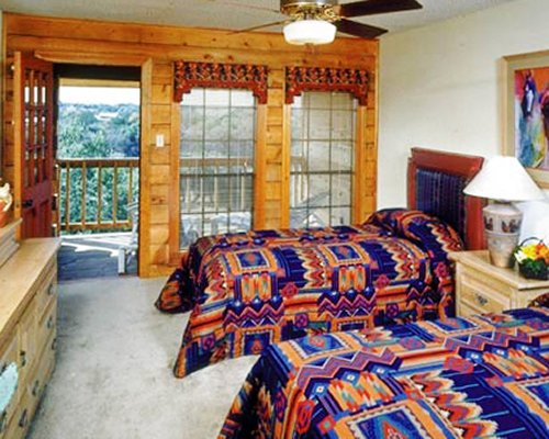 A well furnished bedroom with two twin beds fireplace and balcony.