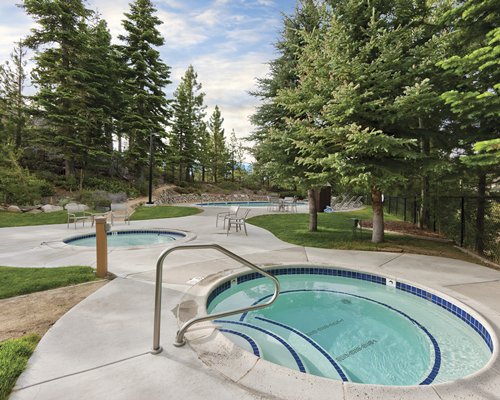 Outdoor hot tubs surrounded by wooded area.