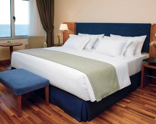 A furnished bedroom with an ocean view.