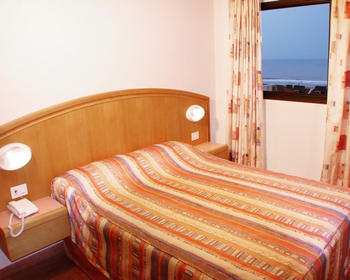 A well furnished bedroom with a double bed and an outside view.