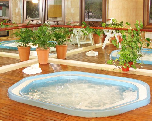An indoor hot tub with chaise lounge chair.