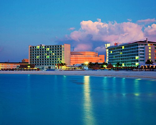 Exterior view of Krystal International Vacation Club alongside beach with neon lights.