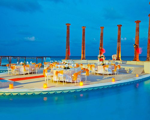An outdoor fine dining restaurant alongside the waterfront at night.