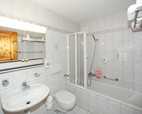 A bathroom with shower sink and vanity.
