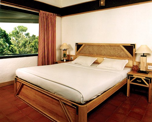 A well furnished bedroom with a double bed and an outside view.