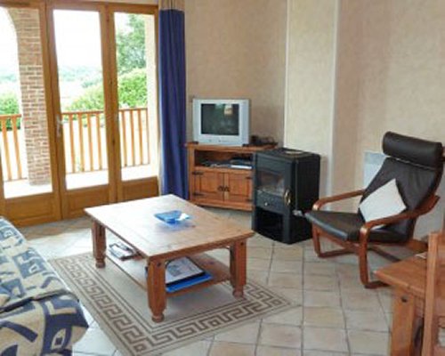 A well furnished living room with television and balcony.