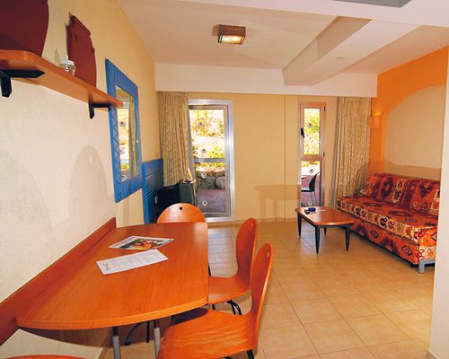 A well furnished living and dining area with television and an outside view.