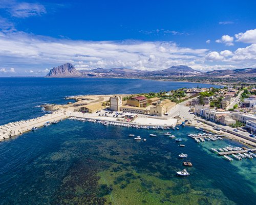 An aerial view of the Tonnara Di Bonagia resort surrounded by the sea.