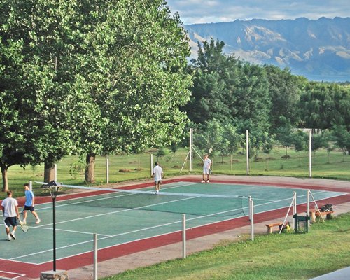 An outdoor tennis court surrounded by trees.