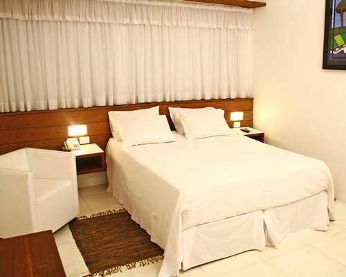 A well furnished bedroom with two lampstands.
