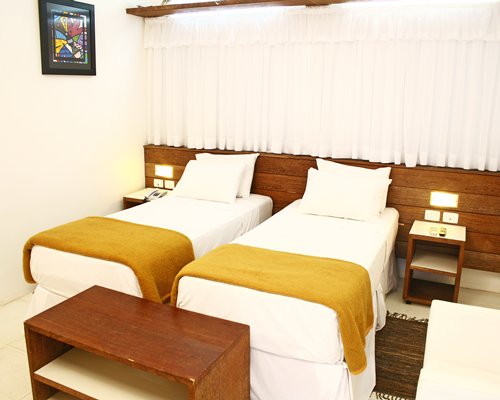 A well furnished bedroom with two twin beds.