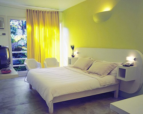 A well furnished bedroom with a television and an outside view.