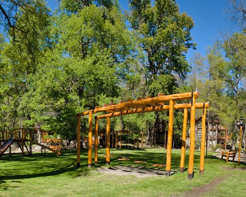 An outdoor playscape surrounded by trees.