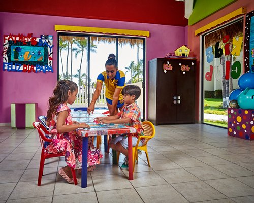 An indoor kids play area with children playing at a table.