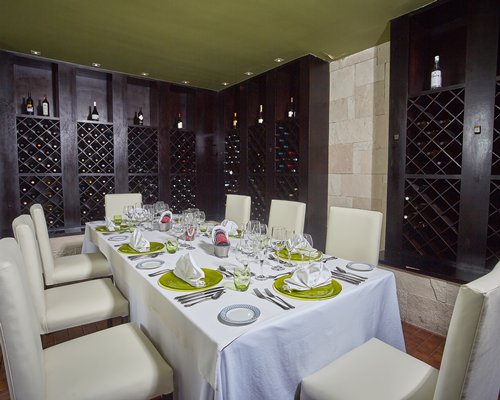 A fine dining restaurant with a large dining table and wall wine racks.
