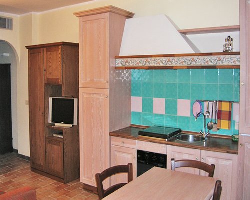 A well equipped kitchen with dining area and a television.