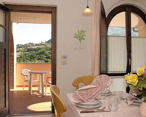 A well furnished dining room alongside a balcony with patio furniture.