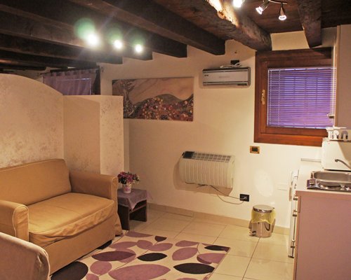 A well furnished living room with double pull out sofa alongside the kitchen area.