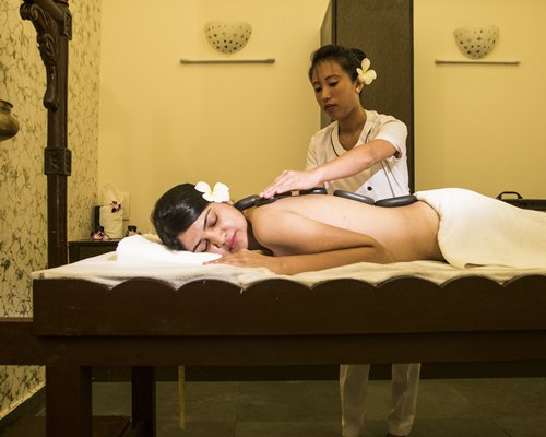 A woman enjoying body massage at a spa.