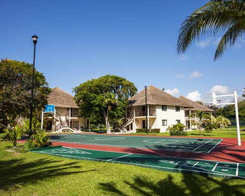 An exterior with outdoor basketball court and shuffleboard in foreground.