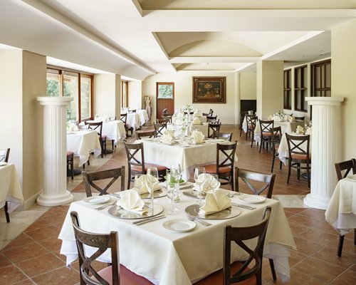 A restaurant with multiple dining tables with windows.