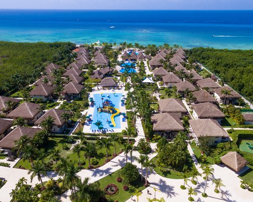 An aerial view of the resort with pools and ocean.