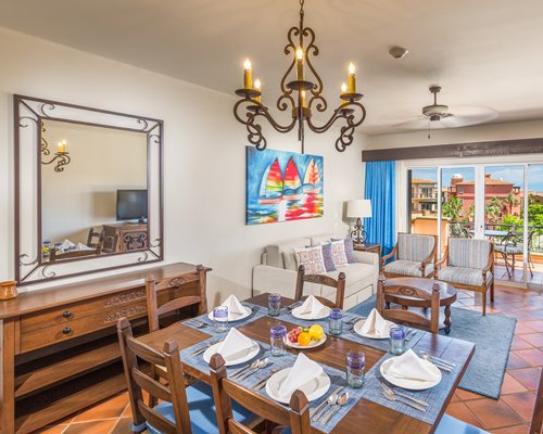 An open plan living and dining area with a television and balcony.