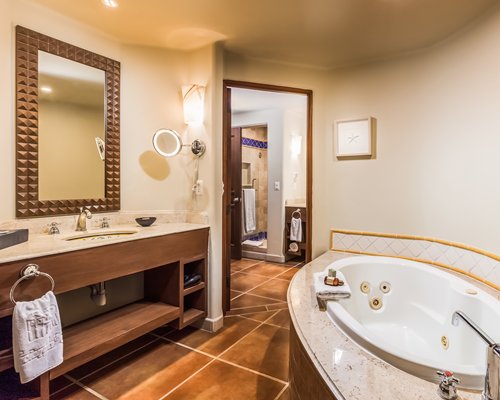 A bathroom with a bathtub and single sink vanity.