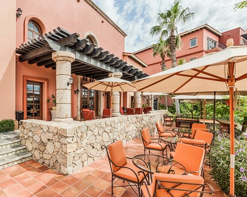 An outdoor dining area with patio and umbrellas alongside the resort.