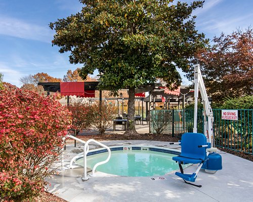 Scenic outdoor swimming pool and hot tub with chaise lounge chairs.