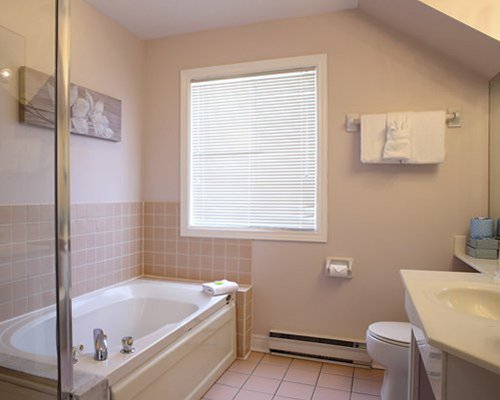 A bathroom with a bathtub shower and single sink.