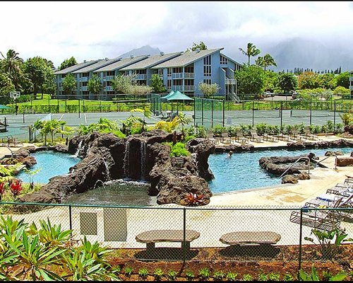 Outdoor recreation area with grotto pool alongside paddle tennis court.