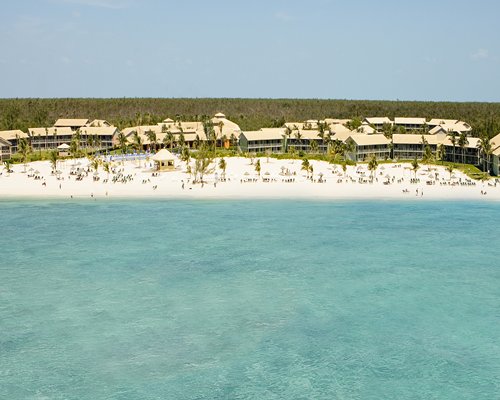 An aerial view of Viva Vacation Club alongside the beach surrounded by wooded area.