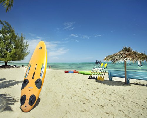 A surfboard on the beach facing the ocean.