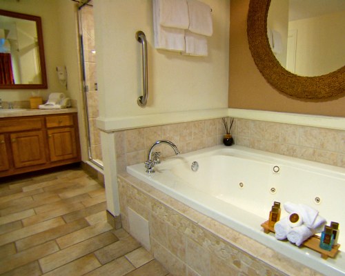 A bathroom with bathtub and a single sink vanity.