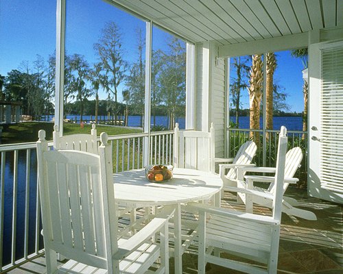A balcony view of a waterfront with patio furniture.