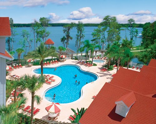 An aerial view of the outdoor swimming pool with hot tub alongside the lake.