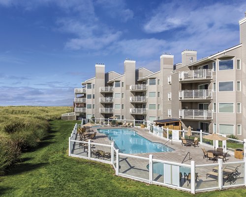 Scenic exterior view of multiple unit balconies with an outdoor swimming pool.