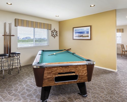 An indoor recreation room with pool table and an outside view.