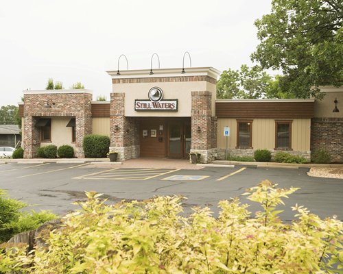 Street view of Still Waters Vacation Club resort with shrubs.