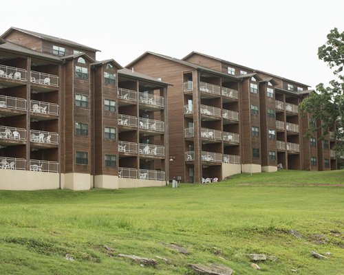An exterior view of multi story resort condos surrounded by lawn.