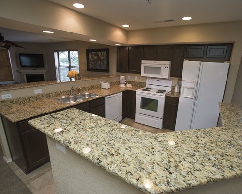 A well equipped kitchen with a stove and microwave oven.