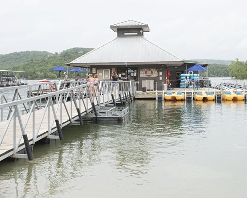 A pier leading to a marina on the lake surrounded by wooded area.