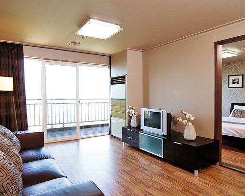 A well furnished living room with a television and balcony.